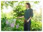 Une femme arrose des plantes avec un tuyau d'arrosage Parkside.