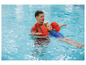 Un enfant apprend à nager dans une piscine avec des brassards de la marque Bema.