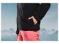 Une veste en polaire noire et un pantalon rose, devant un fond de montagnes