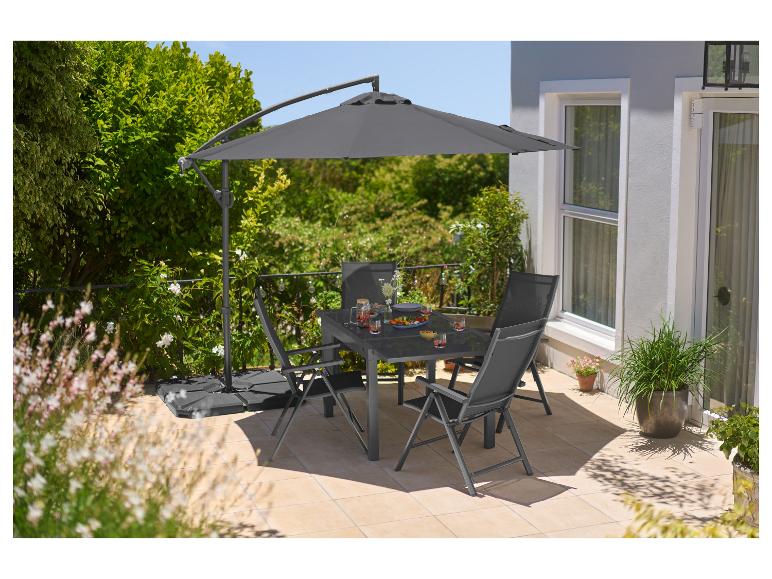 Ensemble repas extérieur avec table grise, chaises et parasol déporté sur une terrasse.