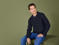 Un homme portant un pull bleu et un jean.