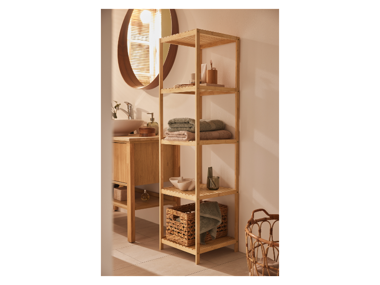 Une étagère en bambou avec des serviettes et des accessoires de salle de bain dans une salle de bain moderne.