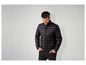Un homme avec une veste noire zippée.