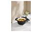 Cocotte en fonte noire avec couvercle, remplie de ragoût, sur un comptoir en marbre.