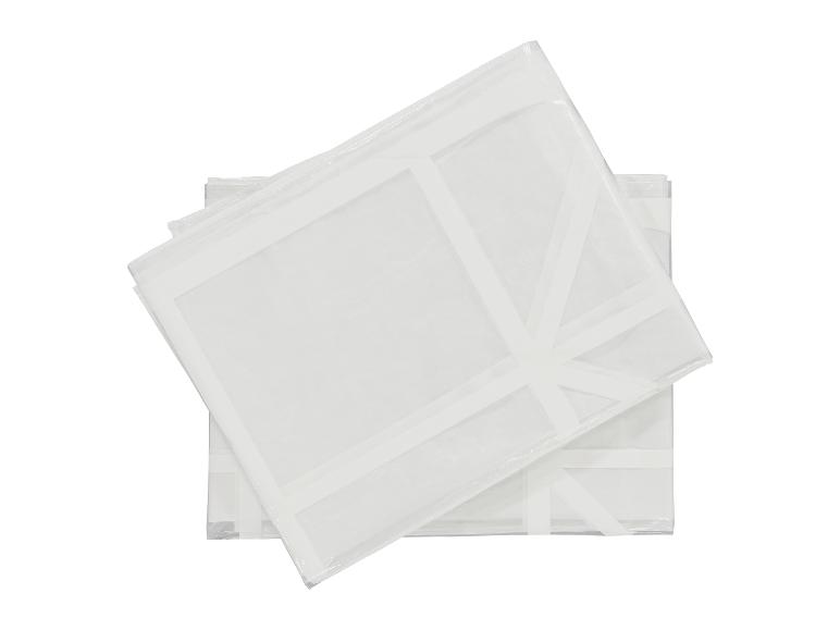 Deux housses de vêtement blanches et transparentes, empilées l'une sur l'autre.