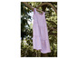 Une robe d'été rose accrochée à une branche d'arbre.