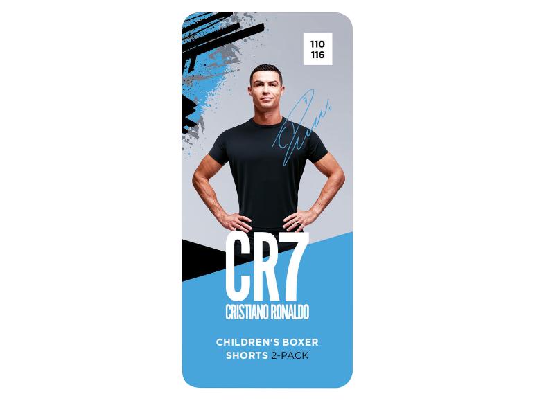 Cristiano Ronaldo en t-shirt noir sur fond graphique bleu et noir, faisant la publicité de boxers pour enfants.