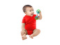 Un bébé en body rouge joue avec un hochet vert et bleu.