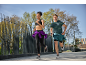 Deux coureurs en tenue de sport, une femme en brassière et legging, un homme en t-shirt et short.