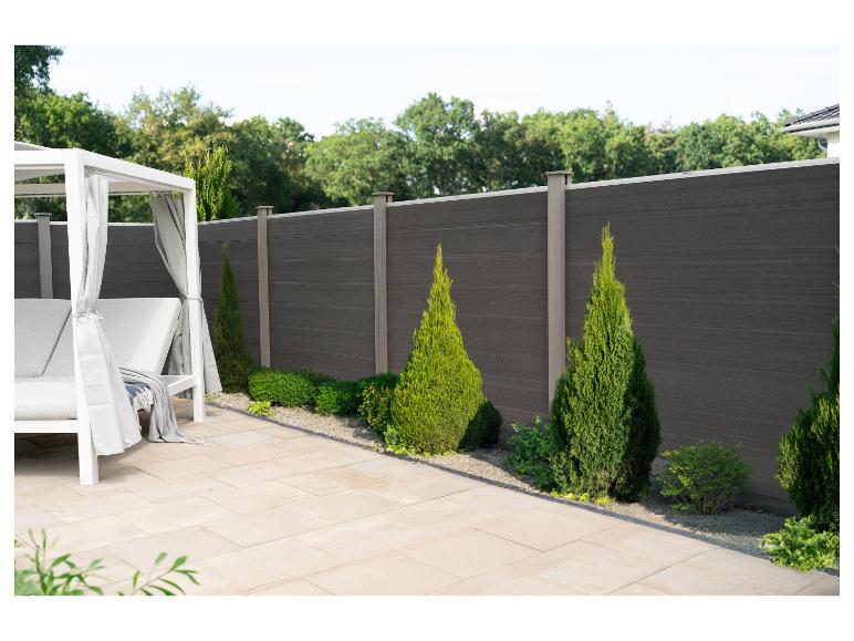 Gazebo de jardin blanc avec rideaux gris et clôture en bois composite foncé.