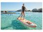 Femme en gilet de sauvetage faisant du paddleboard dans l'eau claire.