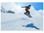 Un snowboarder en plein saut au-dessus d'une piste enneigée