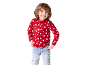 Un garçon souriant portant une chemise de Noël rouge avec motif Père Noël et un jean bleu clair.
