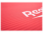 Un tapis de yoga rouge avec le logo Reebok.