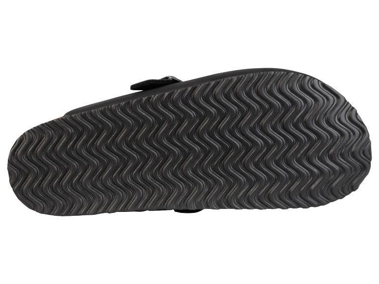 Sandales noires avec une semelle ondulée.