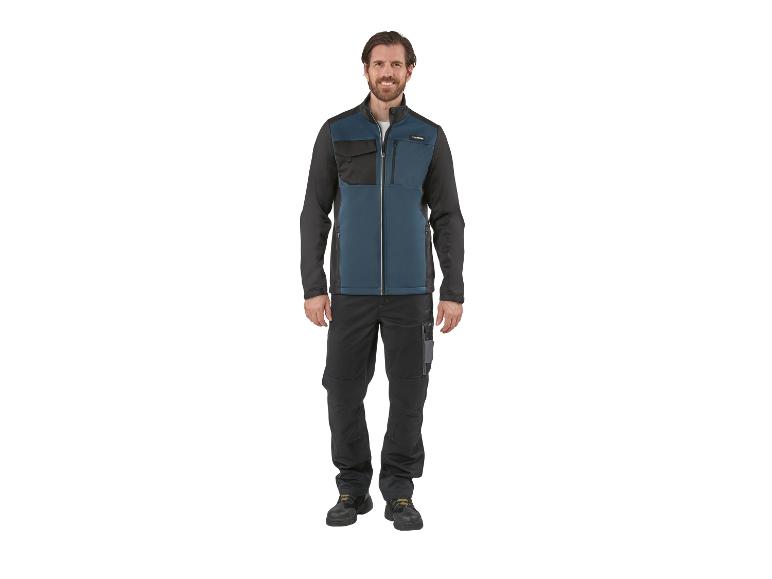 Homme souriant portant une veste de travail bicolore et un pantalon.