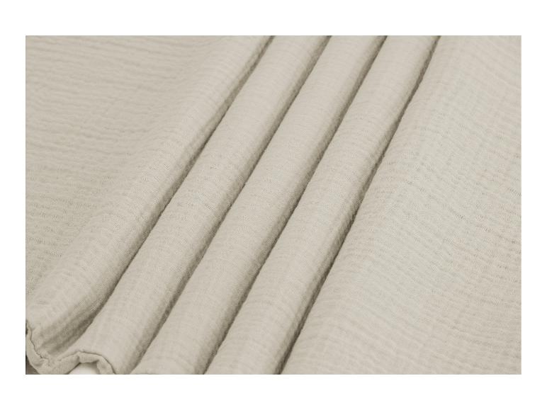 Tissu de mousseline de soie beige clair, plis doux.