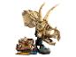 Un grand crâne de Triceratops Lego beige avec une figurine et un site de fouilles fossiles.