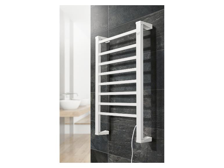 Sèche-serviettes blanc monté sur un mur carrelé foncé dans une salle de bain.