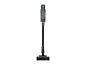 Aspirateur balai sans fil noir et gris avec une brosse motorisée.