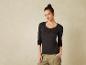 Une femme porte un t-shirt noir à manches longues à imprimé léopard et un pantalon kaki.