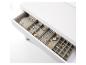 Un coffret à bijoux blanc avec un tiroir rempli de colliers, bracelets, bagues et boucles d'oreilles.