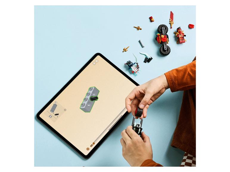 Enfant construisant un ensemble LEGO Ninjago à l'aide d'instructions numériques sur une tablette.