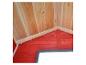 Intérieur d'une cabane en bois avec base rouge et plafond en bois naturel.