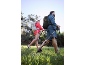Un couple en randonnée avec sacs à dos et bâtons de marche dans la nature.