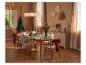 Table de Noël élégamment dressée avec des chaises en bois et des décorations festives.