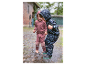Deux enfants en combinaisons de pluie Reima éclaboussent dans une flaque.