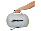Une main tenant un sac de couchage gris avec des points verts de la marque Tampu.