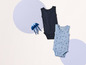 Deux bodies pour bébés avec bordure en dentelle, un bleu à imprimé coquillages et un noir.
