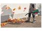 Un homme ramasse des feuilles d'automne avec un aspirateur Bosch.