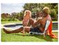 Chaise pliante, maillot de bain et bouteille d'eau près d'une piscine.