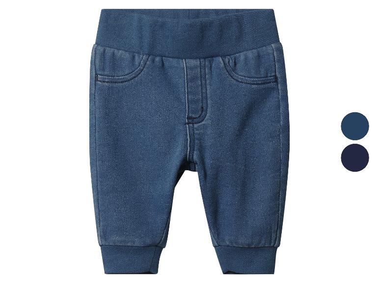 Jean bébé bleu en denim avec taille élastique et poignets.