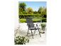 Une chaise pliante noire pour l'extérieur avec une terrasse à l'arrière.