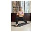 Une femme pratiquant le yoga sur un tapis de yoga noir de la marque Odlo.