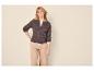 Femme en cardigan tricoté marron et pantalon beige, posant la main sur la hanche.