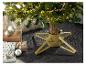 Un support de sapin de Noël doré avec un sapin et des décorations de Noël