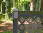 Une clôture de jardin en bois noir avec un motif diagonal.