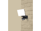Projecteur LED extérieur avec détecteur de mouvement monté sur un mur en briques.