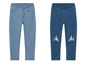 Deux paires de jeans bleus pour filles, l'une à imprimé étoiles et l'autre avec une licorne arc-en-ciel.