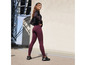 Femme en leggings violets et haut de sport noir.