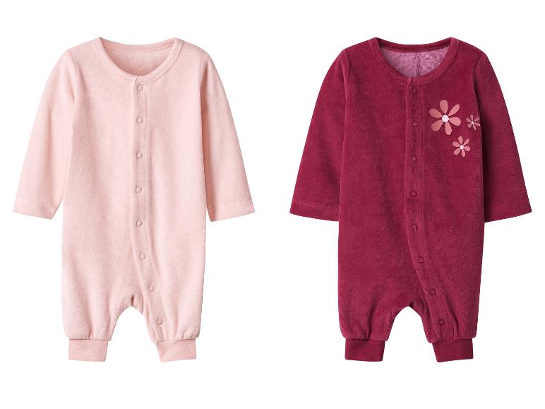 Deux grenouillères pour bébé en rose et bordeaux, la dernière avec des appliqués floraux.