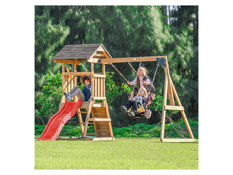 Enfants jouant sur une balançoire en bois avec toboggan rouge dans un jardin.