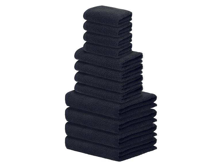Pile de serviettes de bain noires de différentes tailles sur fond blanc.