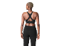 Femme de dos portant un soutien-gorge de sport noir et un pantalon de sport noir.