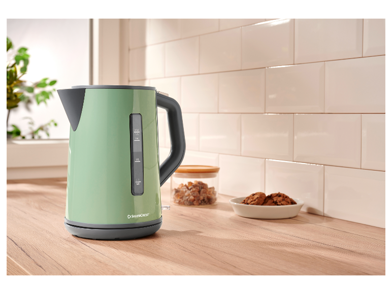 Une bouilloire vert menthe SilverCrest sur un comptoir en bois.