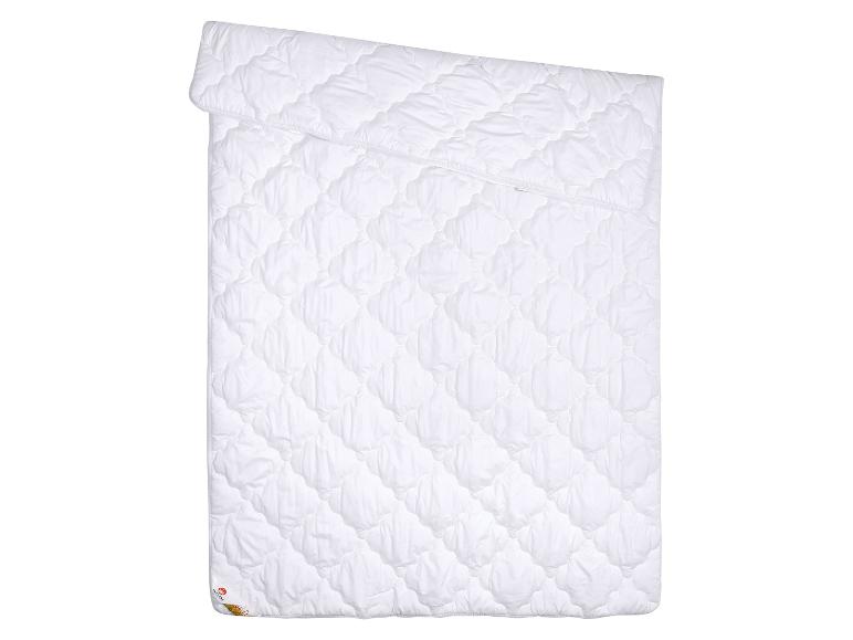 Couette blanche matelassée avec un motif de losanges, pliée en deux.